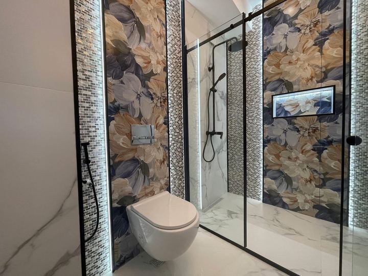 Walk-in shower with a floral tile wall, a glass panel and a wall-hung toilet - Sani Building Corp
