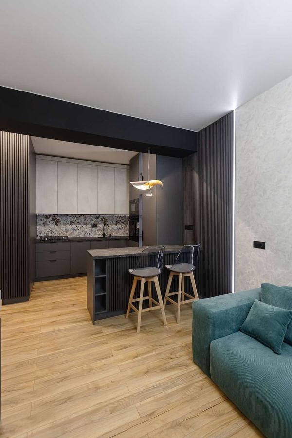 Open Kitchen with Breakfast Bar - Matte cabinets and stone counters opening to the living room - Sani Building Corp