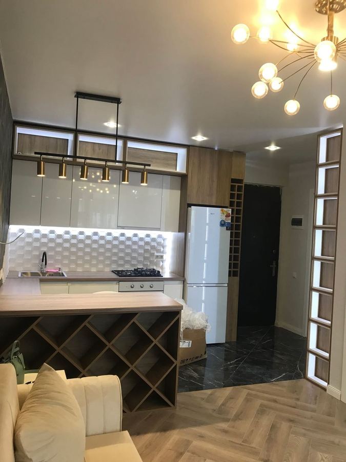Gloss Kitchen with Wine Rack - Lit open boxes above, wine rack under the counter - Sani Building Corp