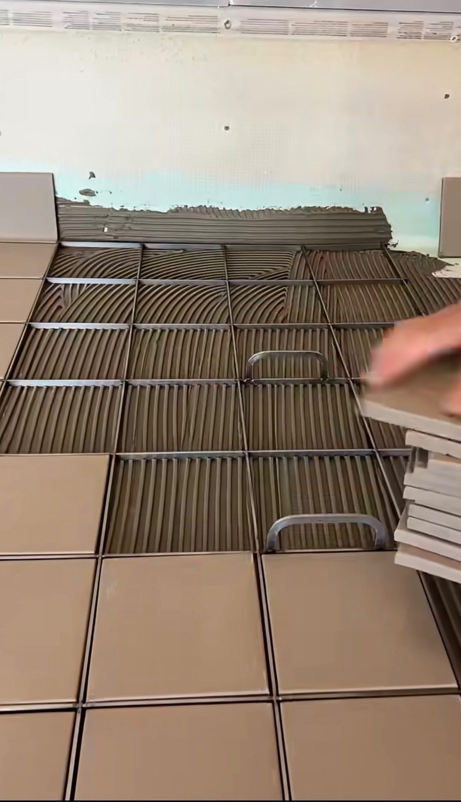 Commercial tile installation NYC — large-format wall tile being set by Sani Building Corp