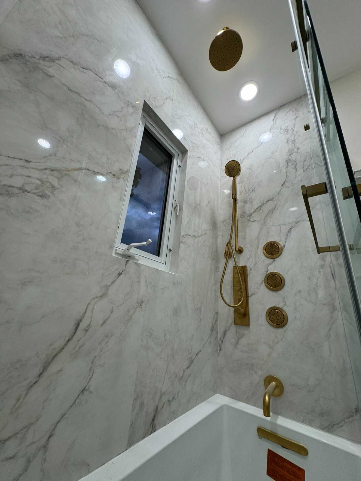 Master bathroom remodel in Park Slope with marble tile, freestanding tub and matte black fixtures